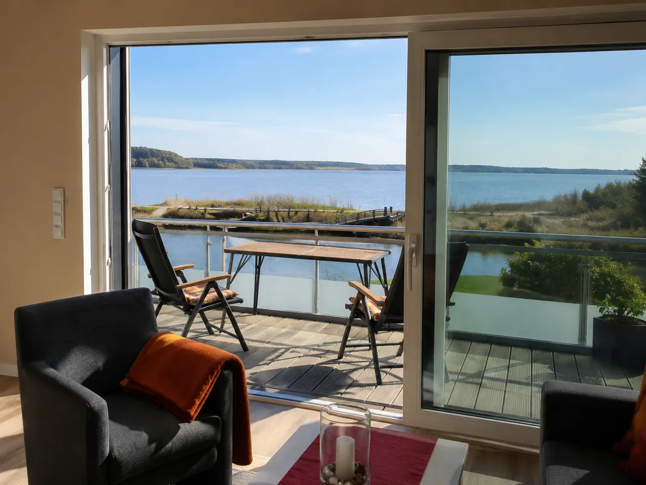 Wohnbereich der Ferienwohnung „Rot“ mit Balkon und Blick auf den Bederkesaer See