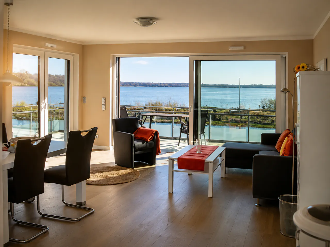 Wohnzimmer der Ferienwohnung „Beige“ mit Balkon und Blick auf den Bederkesaer See